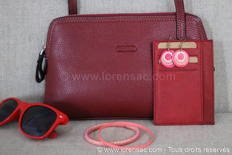 KL028 - Petit sac / Pochette pour femme en cuir rouge avec porte carte mise en situation de la Pochette femme bandoulière en cuir véritable rouge avec lunettes et un porte carte touge